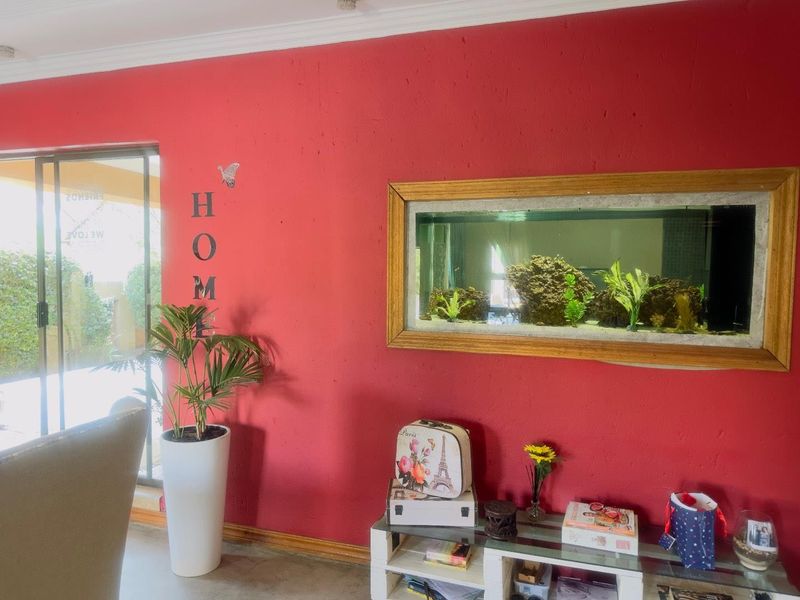 A living room featuring a prominent built-in wall aquarium and sliding glass doors leading to an outdoor area.
