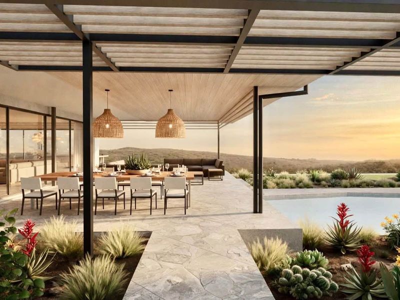 A modern covered patio featuring stone paving, a pergola structure, and seamless access to a swimming pool with scenic landscape views.