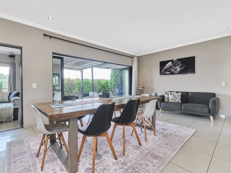 Spacious open-plan living and dining area featuring large sliding glass doors that provide seamless access to the outdoor patio and natural light.