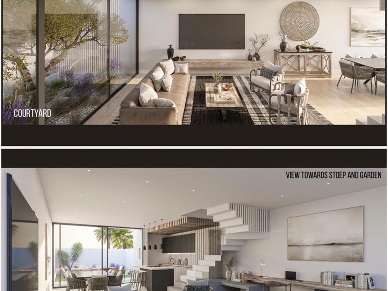 Modern open-plan living area featuring a sleek kitchen, integrated staircase, and large sliding glass doors opening to a private courtyard.