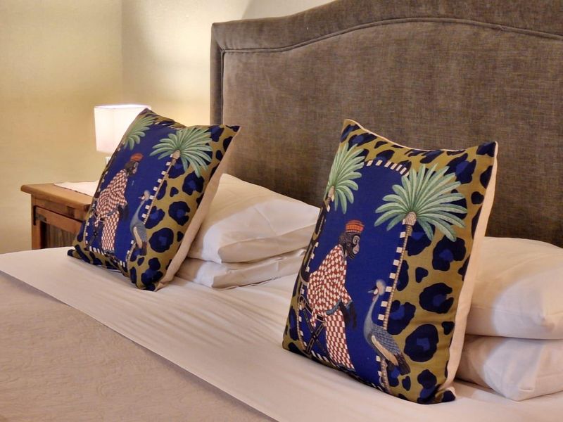 A close-up view of a bedroom featuring a neutral-toned upholstered headboard.