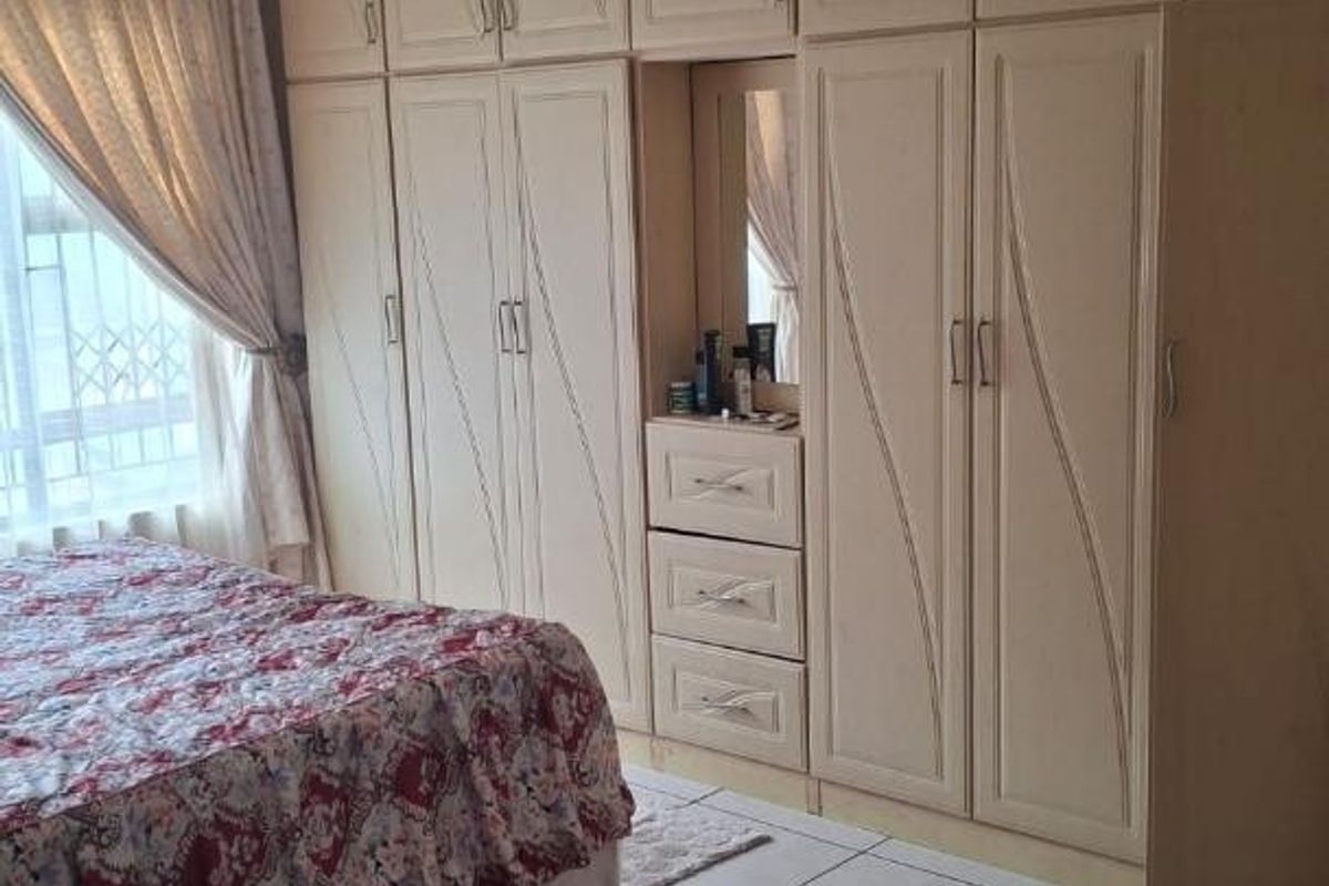 A bedroom featuring extensive built-in cabinetry with integrated vanity and tiled flooring.