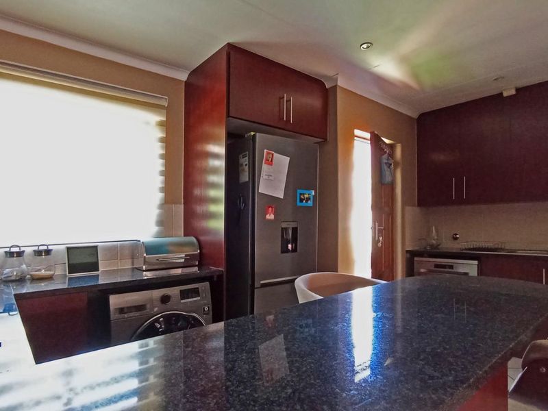 A functional kitchen featuring dark wood cabinetry, granite countertops, and integrated appliances, offering a practical layout for daily cooking and meal preparation.