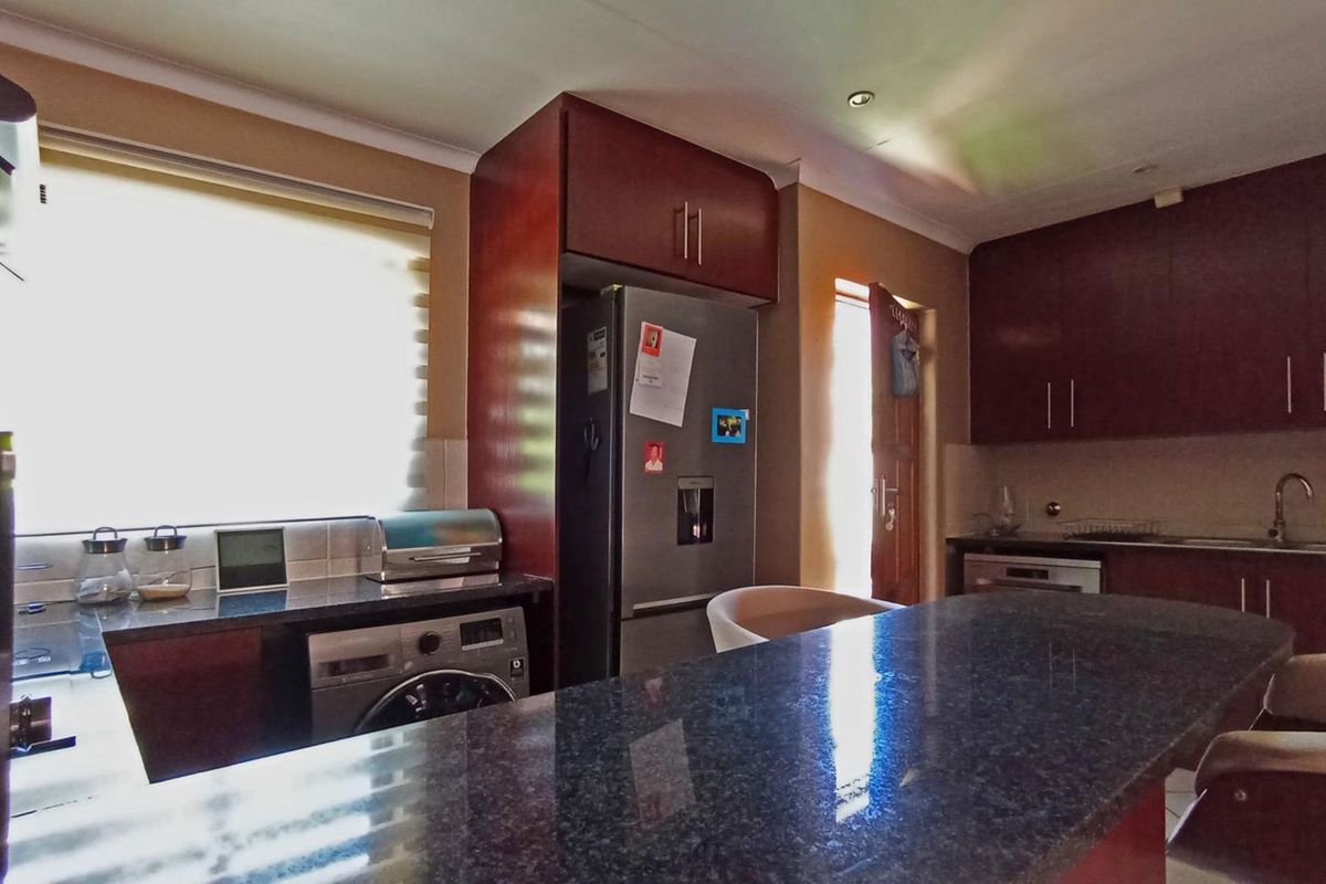 A functional kitchen featuring dark wood cabinetry, granite countertops, and integrated appliances, offering a practical layout for daily cooking and meal preparation.