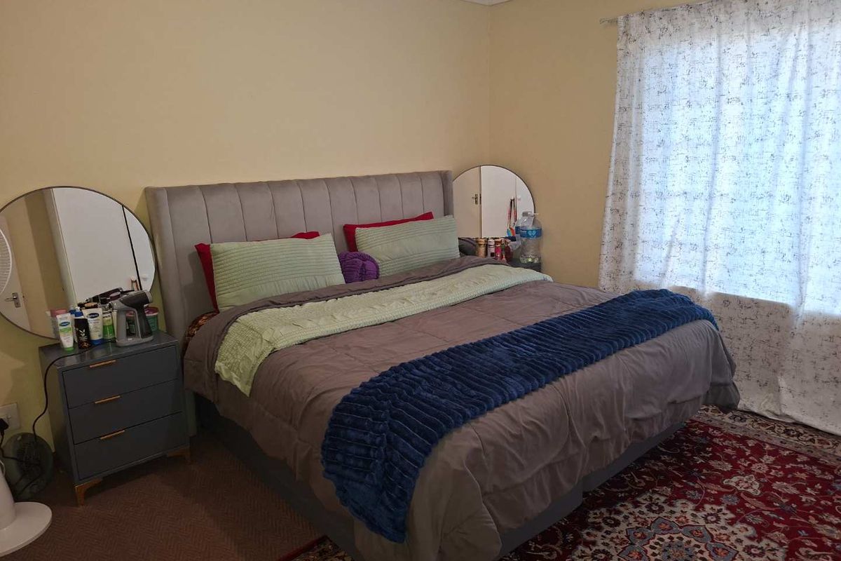 A standard bedroom featuring carpeted flooring and window treatments, providing a functional and comfortable living space.