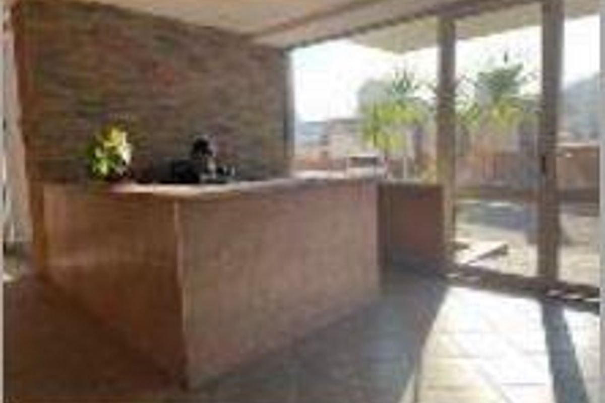 Office reception area featuring a built-in desk, stone accent wall, and large glass doors providing natural light and exterior access.
