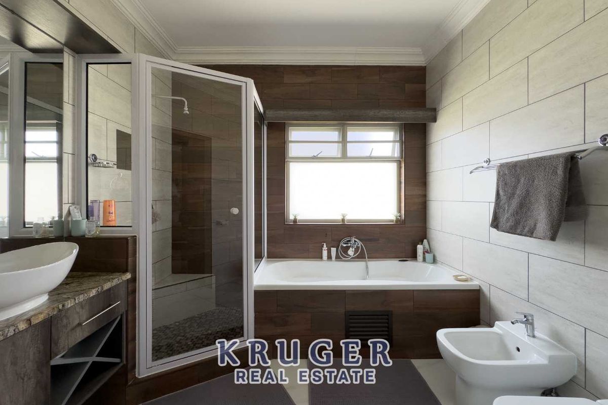 Modern bathroom featuring a glass-enclosed shower, a built-in bathtub with wood-look tiling, a vanity with vessel sink, and a bidet.