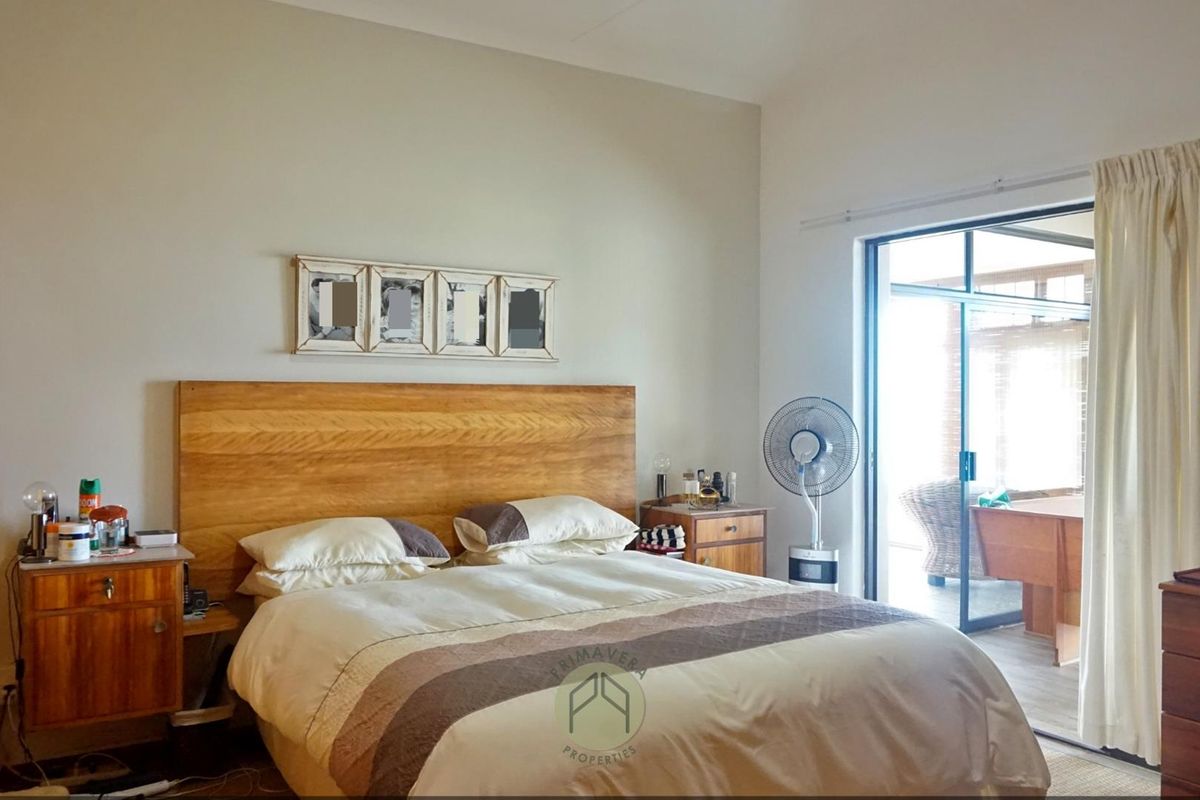 Spacious bedroom featuring a built-in wardrobe and large sliding glass doors that provide direct access to an outdoor patio area.