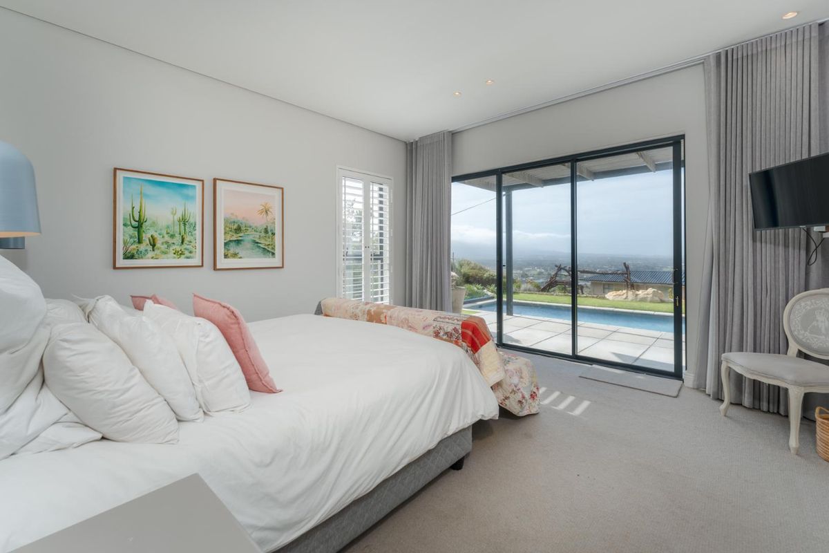 Spacious bedroom featuring neutral carpeting, recessed lighting, and large sliding glass doors providing direct access to the patio and pool area.