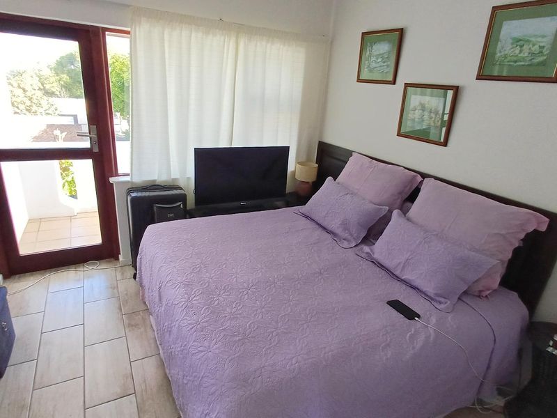 A bedroom featuring tiled flooring and a glass panel door providing access to an outdoor area.