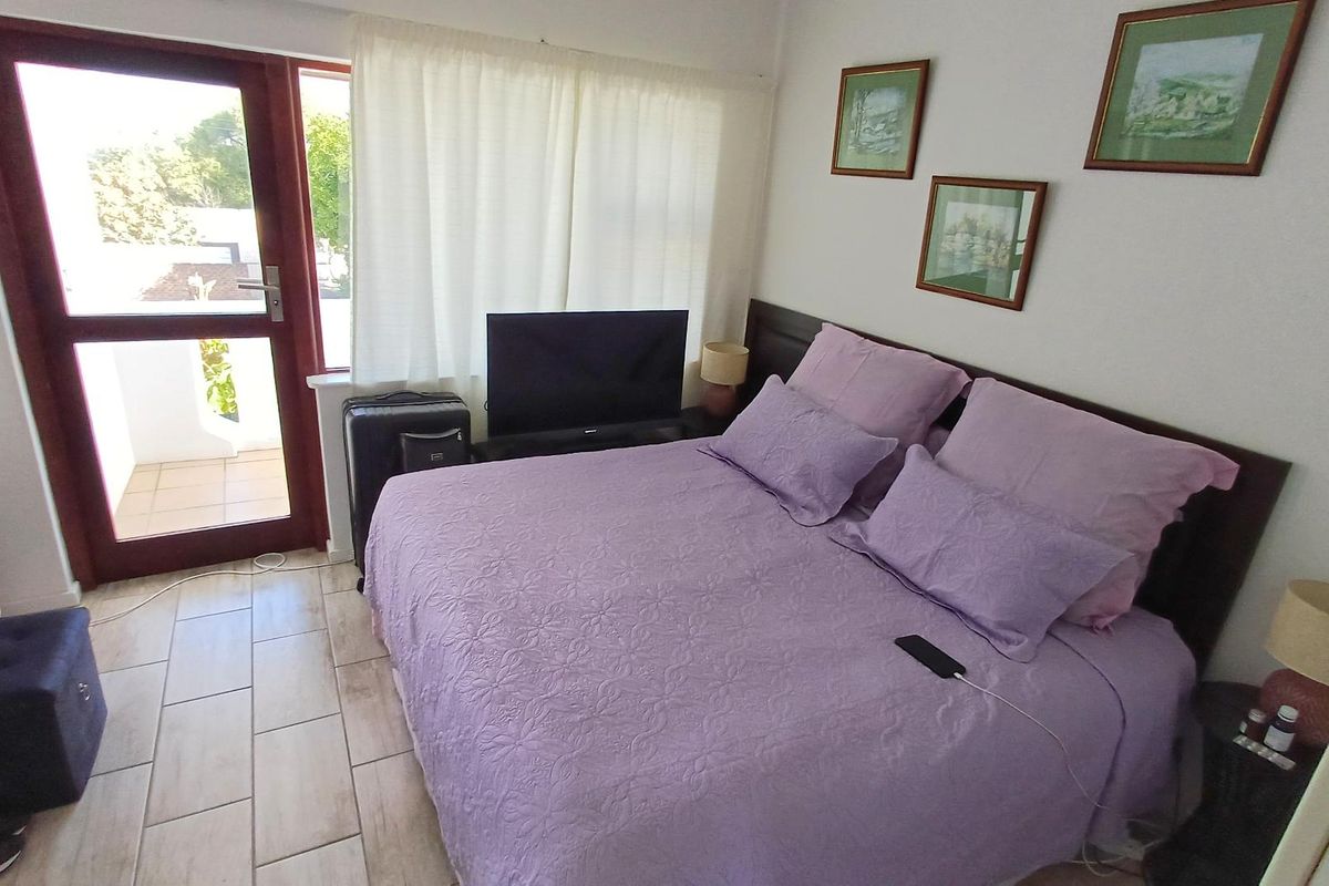 A bedroom featuring tiled flooring and a glass panel door providing access to an outdoor area.