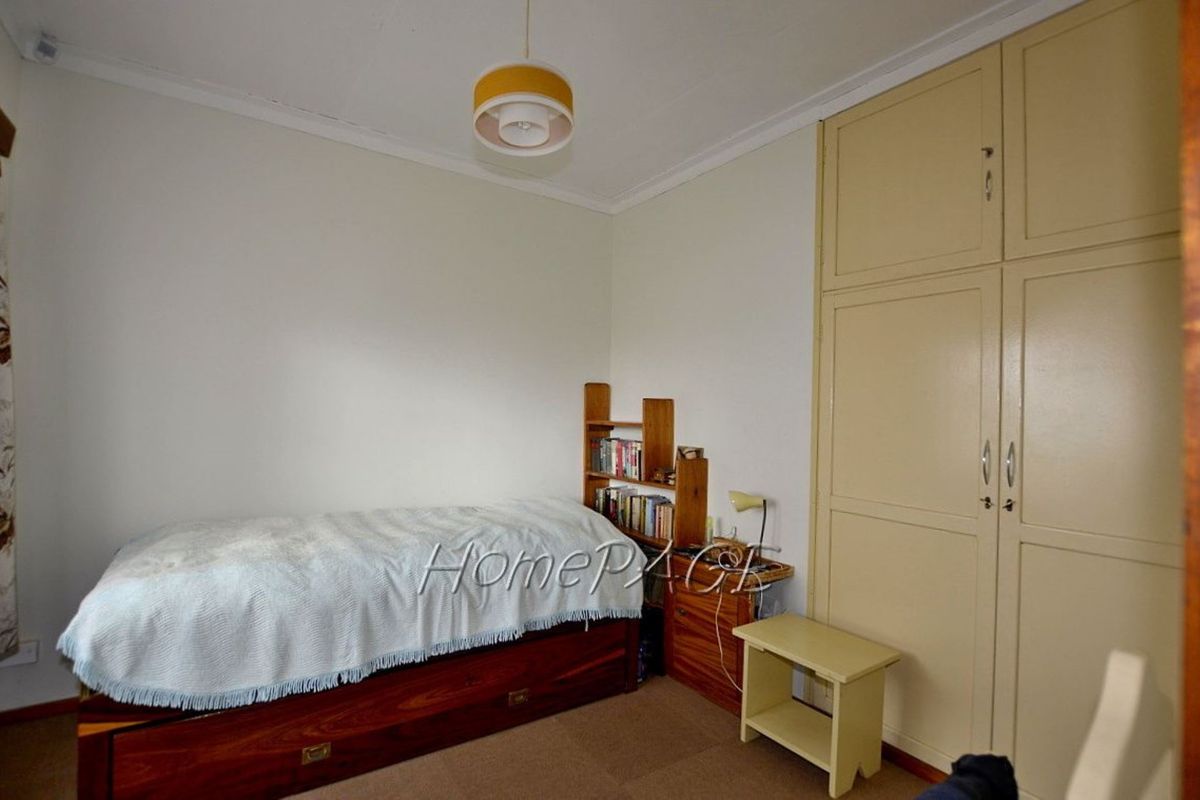 A functional bedroom featuring built-in storage cupboards and neutral wall finishes, providing a practical space for rest or study.