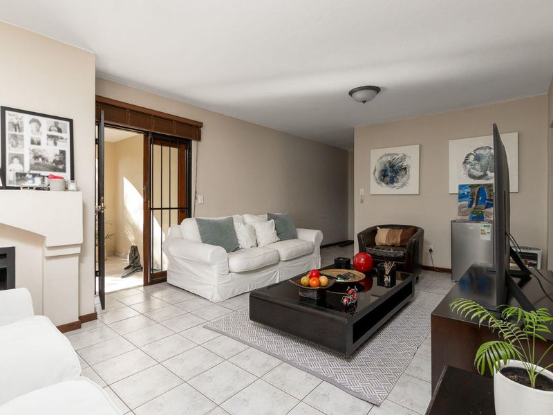 A living room featuring tiled flooring, a fireplace, and a sliding glass door leading to an outdoor area.