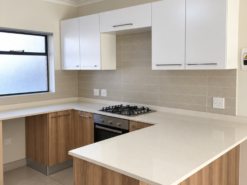Modern kitchen featuring wood-grain cabinetry, white stone countertops, a gas hob, built-in oven, and neutral tiled backsplash in a clean, open layout.