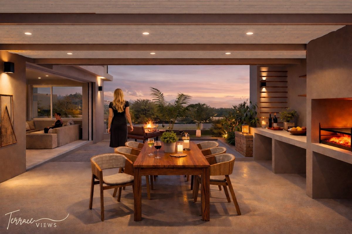 A spacious covered patio featuring a built-in fireplace, recessed lighting, and a seamless transition to an outdoor living area with sunset views.