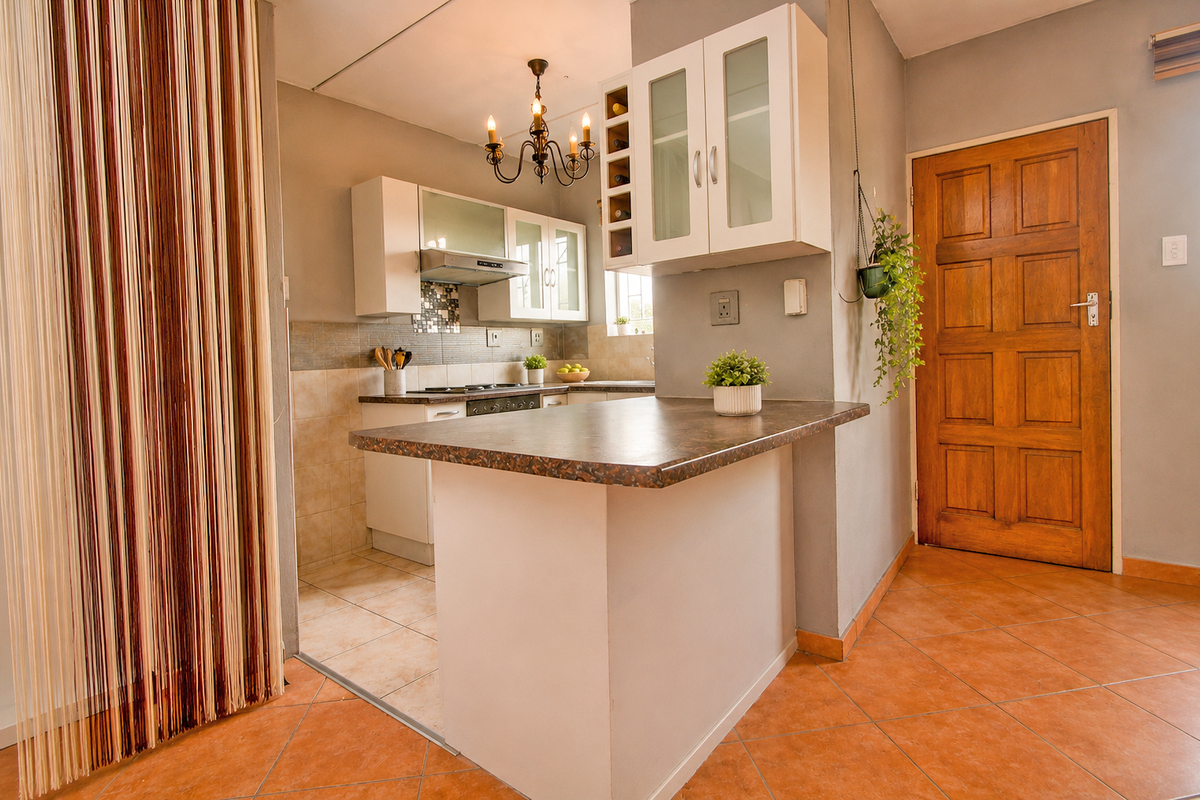 A functional kitchen featuring built-in cabinetry, a breakfast bar, and tiled flooring, providing a practical layout for daily meal preparation.