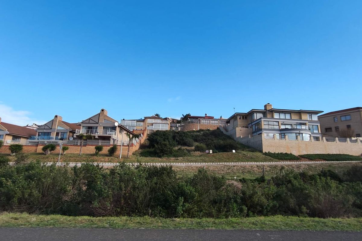 A wide-angle view of residential properties situated on an elevated slope, featuring terraced retaining walls and multi-level architectural designs.