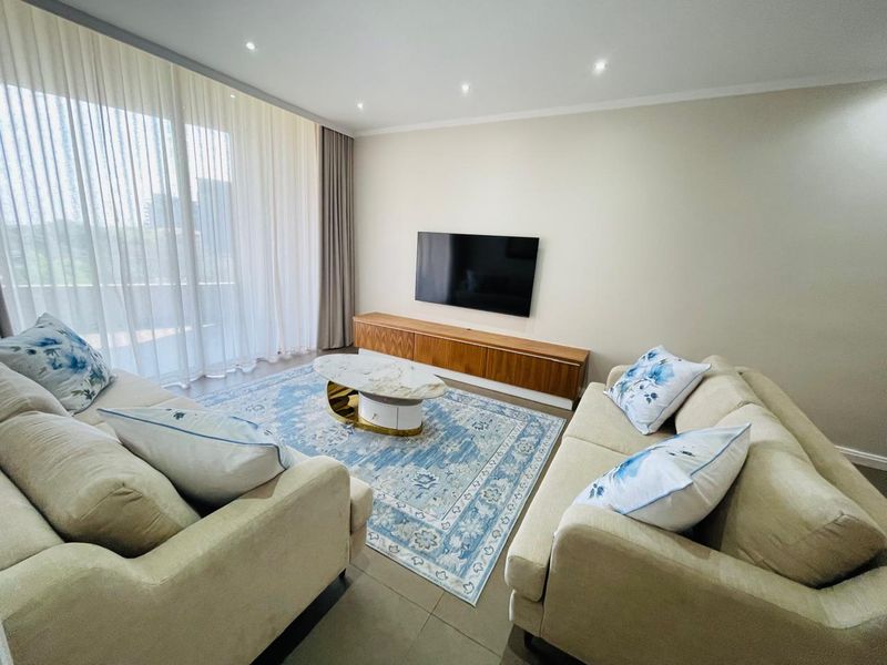 A bright and modern living room featuring tiled flooring, recessed downlighting, and large sliding glass doors leading to an outdoor area.