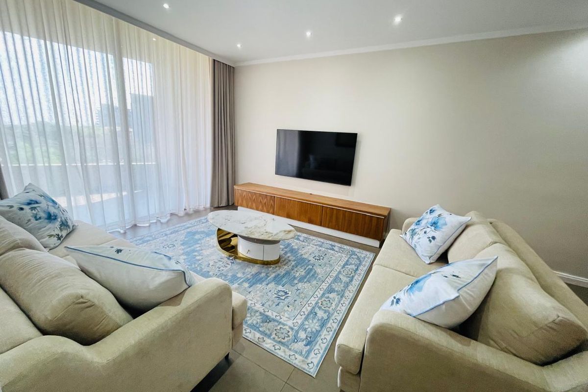 A bright and modern living room featuring tiled flooring, recessed downlighting, and large sliding glass doors leading to an outdoor area.