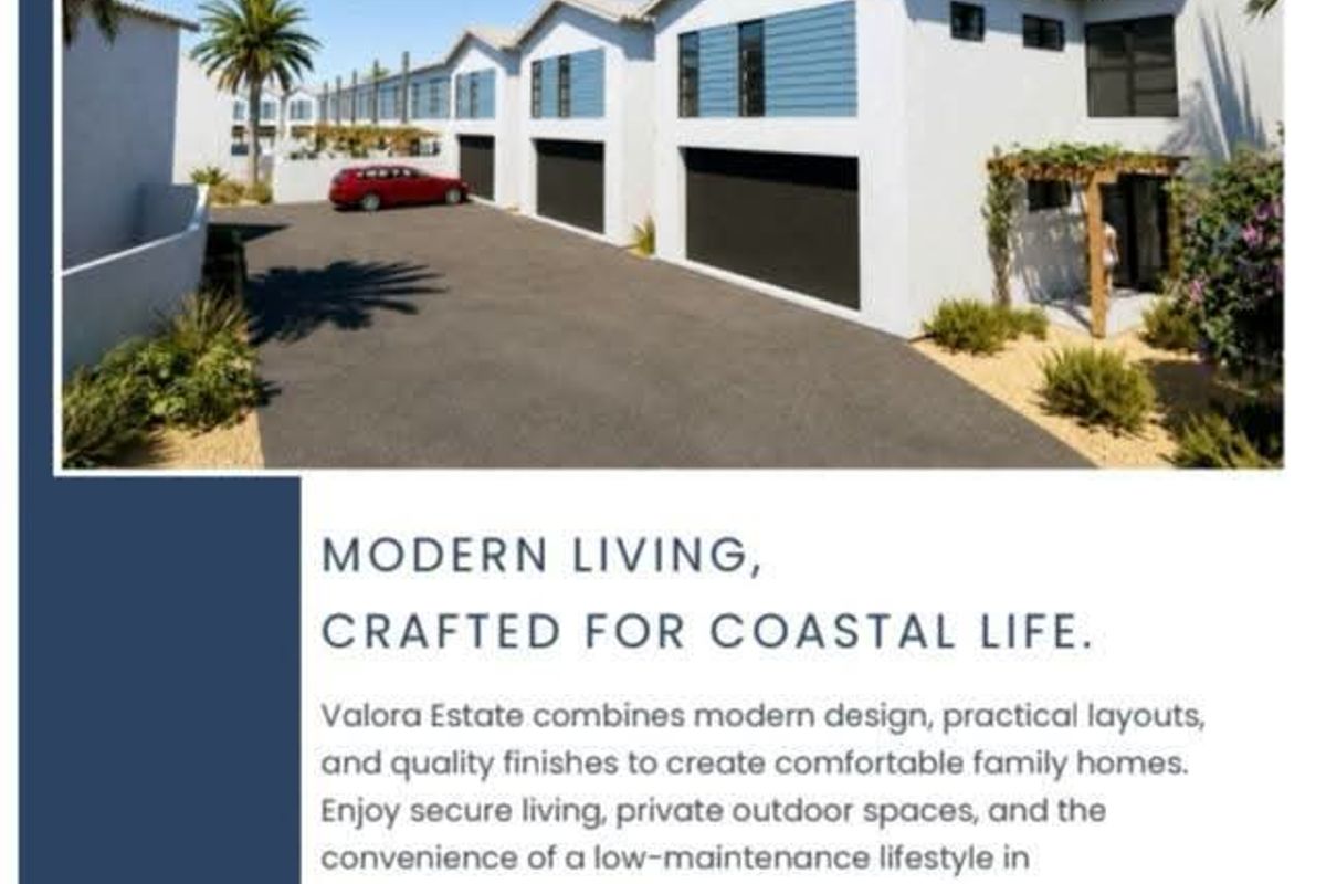 Modern residential estate facade featuring double garages, paved driveway, and clean architectural lines in a coastal setting.