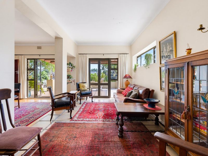 Spacious living room featuring tiled floors, clerestory windows, and double glass doors providing direct access to the outdoor patio area.