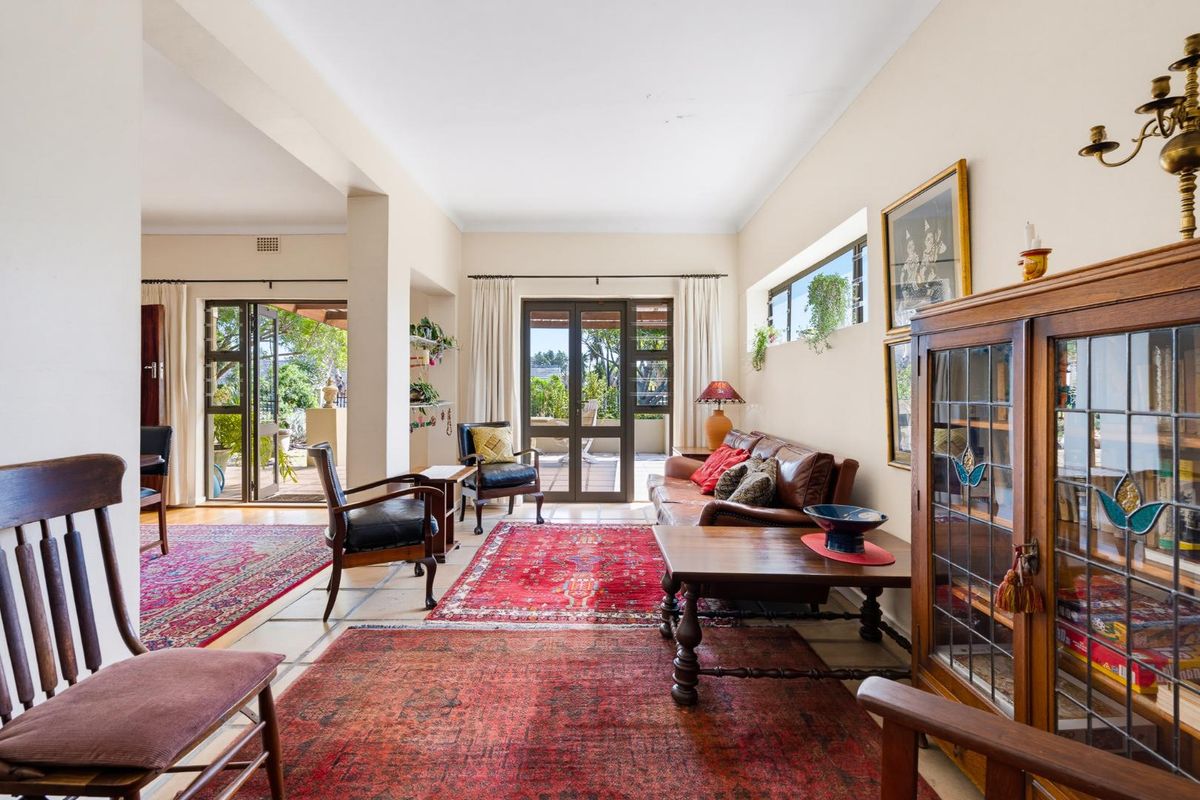 Spacious living room featuring tiled floors, clerestory windows, and double glass doors providing direct access to the outdoor patio area.