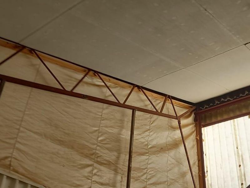 Interior view of an industrial utility space featuring exposed steel roof trusses, insulated wall panels, and corrugated metal cladding.