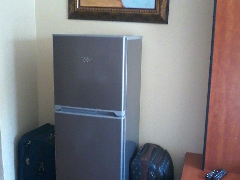 A corner view of a room featuring tiled flooring and neutral wall paint.