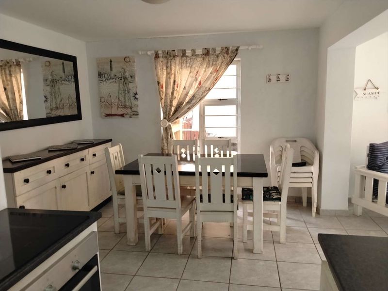 Open-plan dining area featuring tiled flooring and built-in cabinetry, seamlessly connected to the kitchen space.