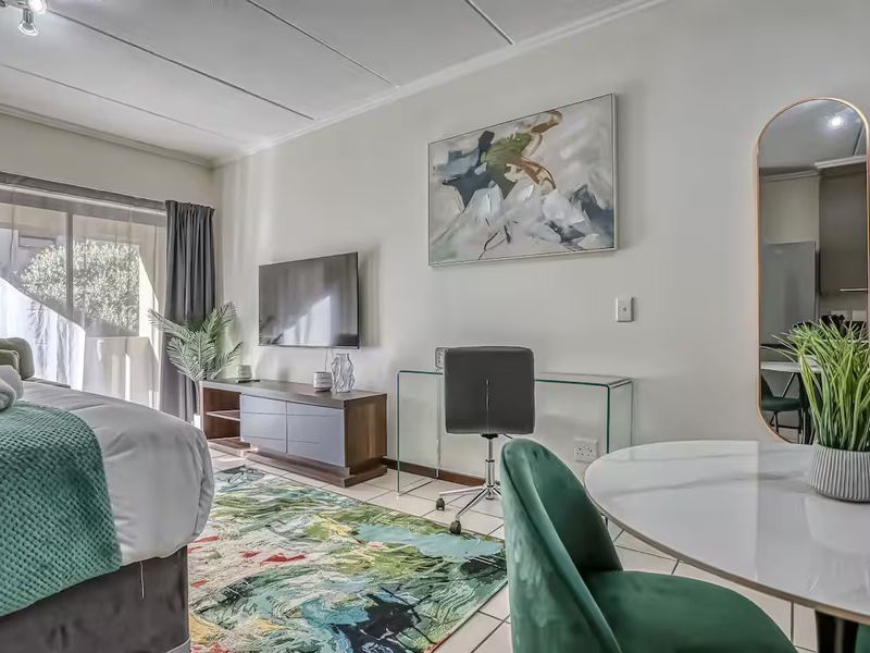 A well-lit bedroom featuring tiled flooring, a sliding glass door leading to an outdoor area, and modern ceiling panel finishes.