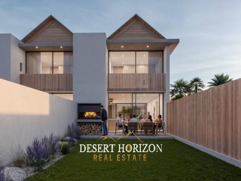 Rear view of a modern townhouse featuring a private garden, built-in braai area, and upper-level balconies with timber screening.
