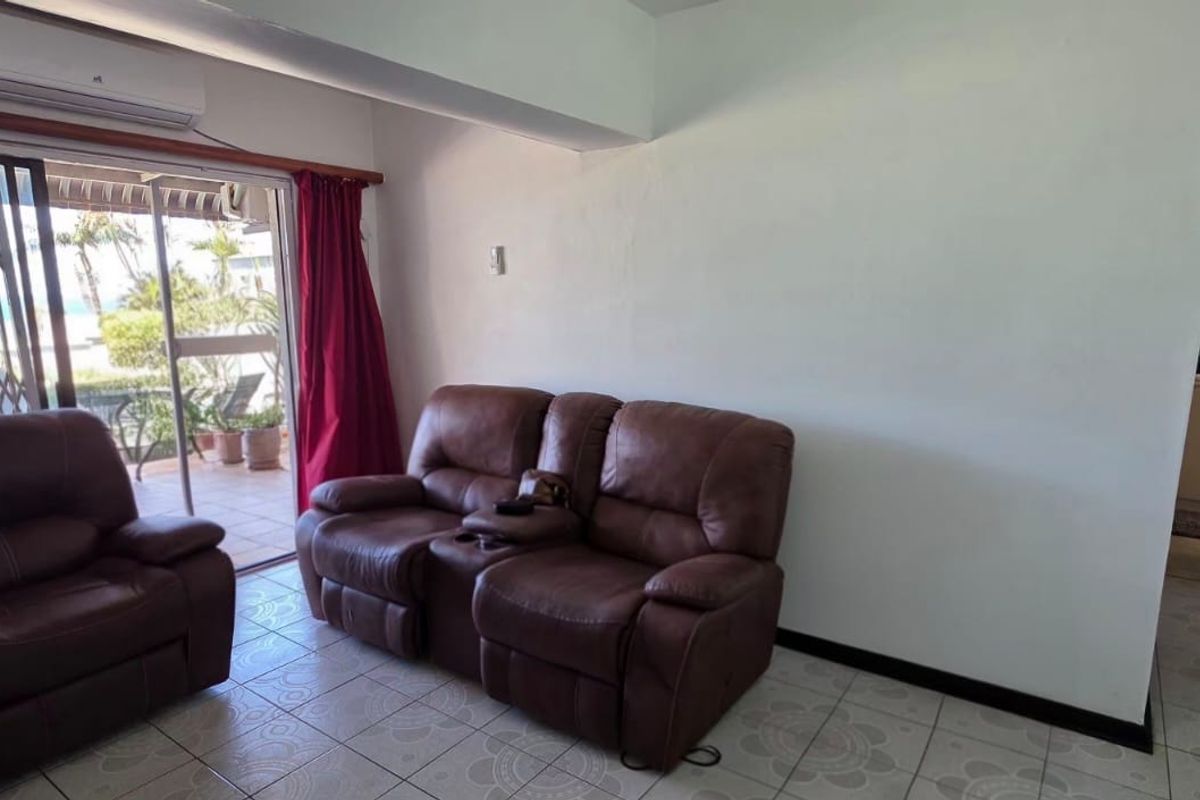 Living room featuring ceramic tiled flooring, a wall-mounted air conditioning unit, and a sliding glass door providing access to an outdoor patio area.