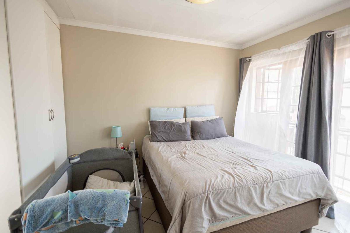 A functional bedroom featuring built-in cupboards and tiled flooring, providing a comfortable and practical living space.