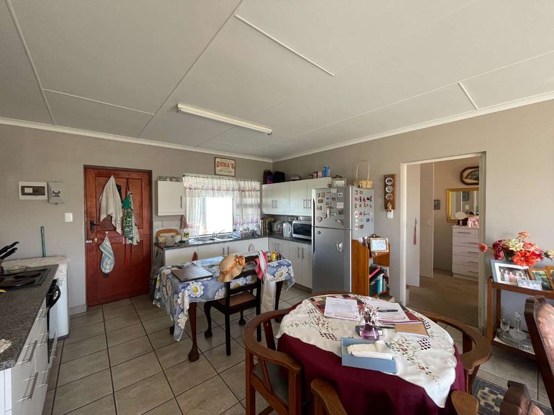 A functional kitchen featuring built-in cabinetry, a double sink, and tiled flooring, offering potential for modernization and aesthetic updates.