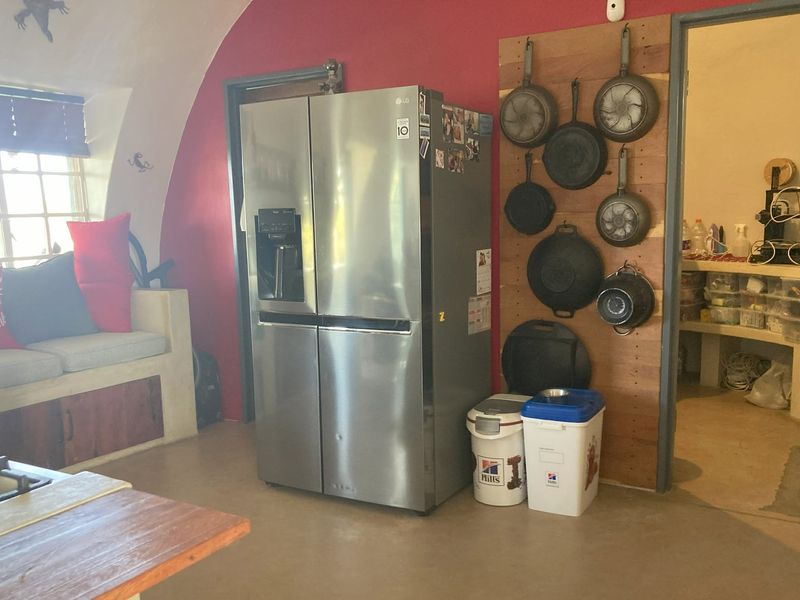 Kitchen area featuring a vaulted ceiling, built-in bench seating, and a functional layout with direct access to a secondary utility or pantry space.