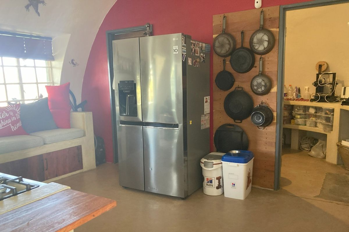 Kitchen area featuring a vaulted ceiling, built-in bench seating, and a functional layout with direct access to a secondary utility or pantry space.