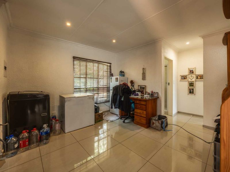 A functional utility space featuring tiled flooring, recessed downlighting, and venetian blinds, offering versatile potential for storage or a home workspace.