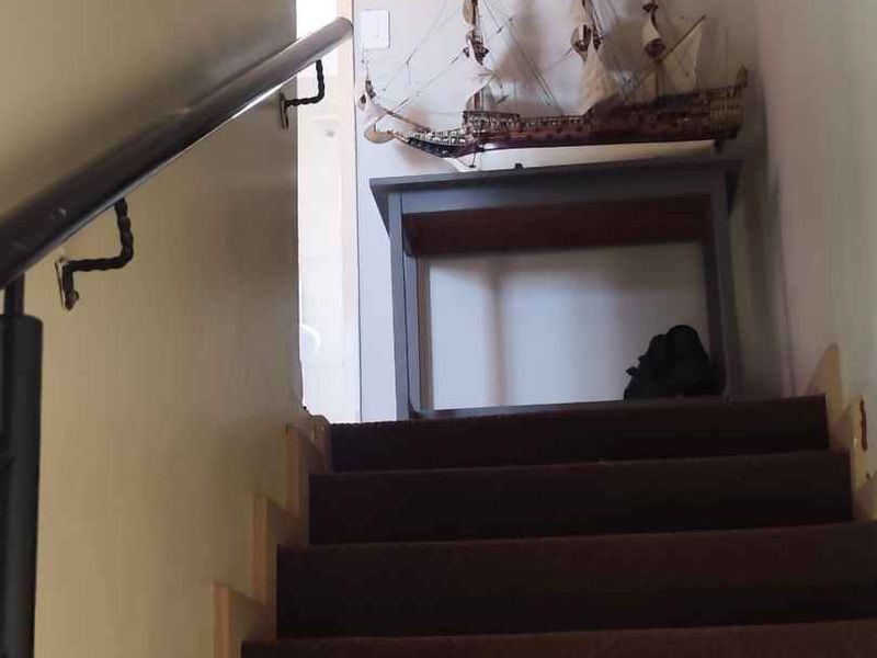 A staircase with a handrail leading to an upper landing area.