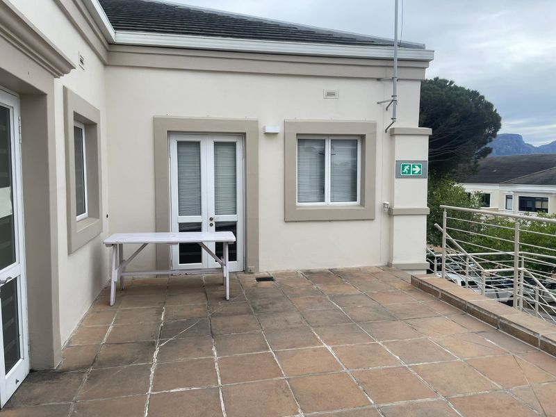 A spacious outdoor balcony featuring tiled flooring and metal balustrades, providing an accessible exterior area for the office premises.