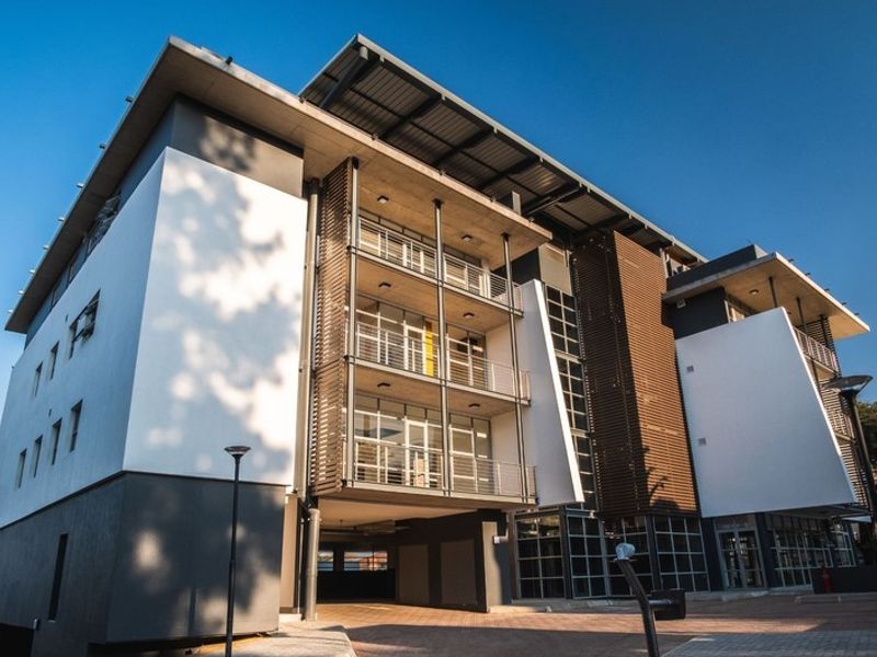 Modern multi-story office building featuring contemporary architectural design with glass facades, metal louvers, and integrated balcony structures.