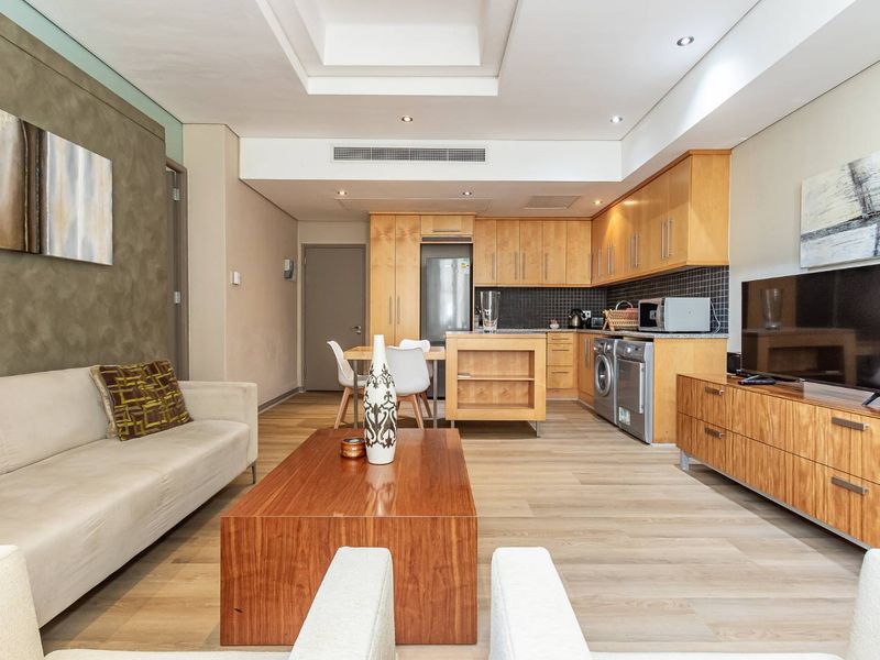 Spacious open-plan living area featuring a modern kitchen with built-in cabinetry, integrated appliances, and seamless flow to the lounge space.