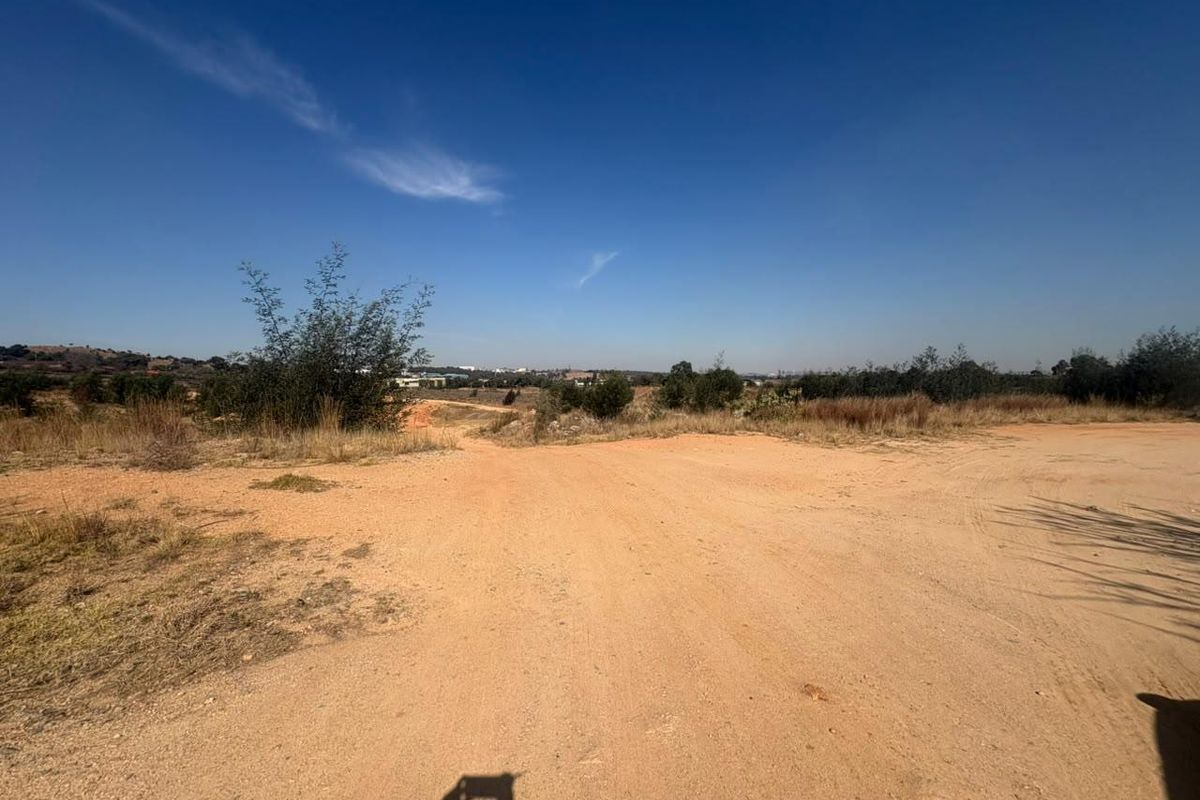 An expansive view of an undeveloped industrial plot featuring natural terrain and open land.
