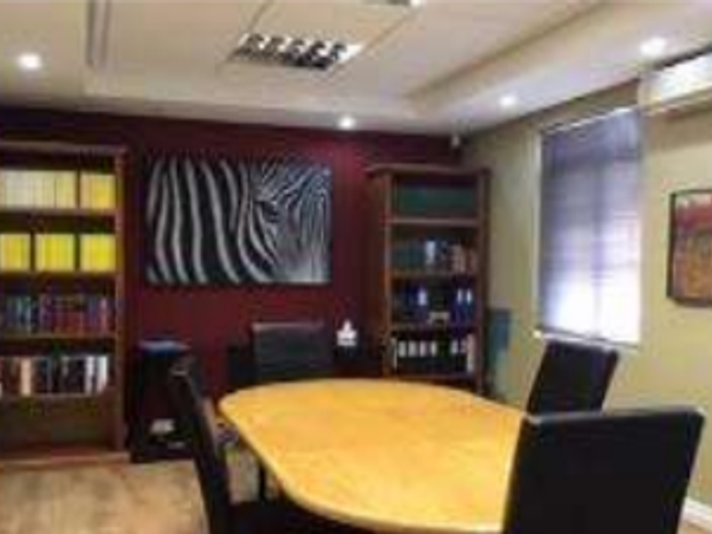 A professional office space featuring recessed ceiling lighting, an integrated air conditioning unit, and laminate flooring.