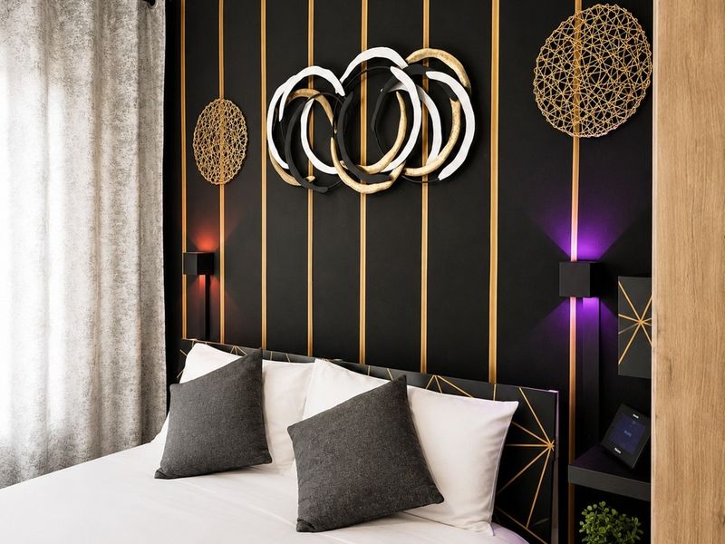 A modern bedroom featuring a stylish black and gold accent wall with integrated lighting and built-in bedside shelving.