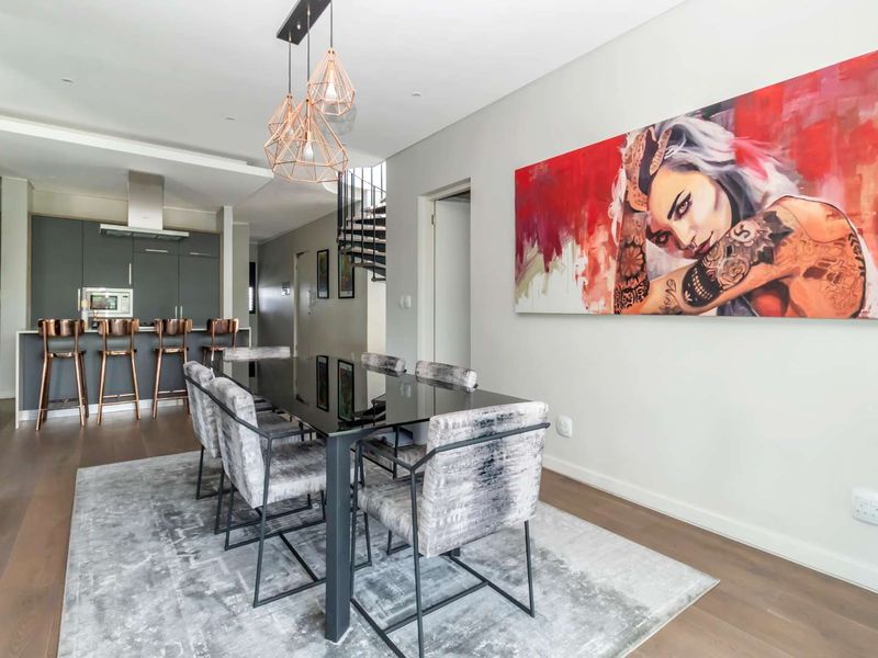Modern open-plan dining and kitchen area featuring sleek cabinetry, integrated appliances, and a striking spiral staircase in a contemporary penthouse setting.