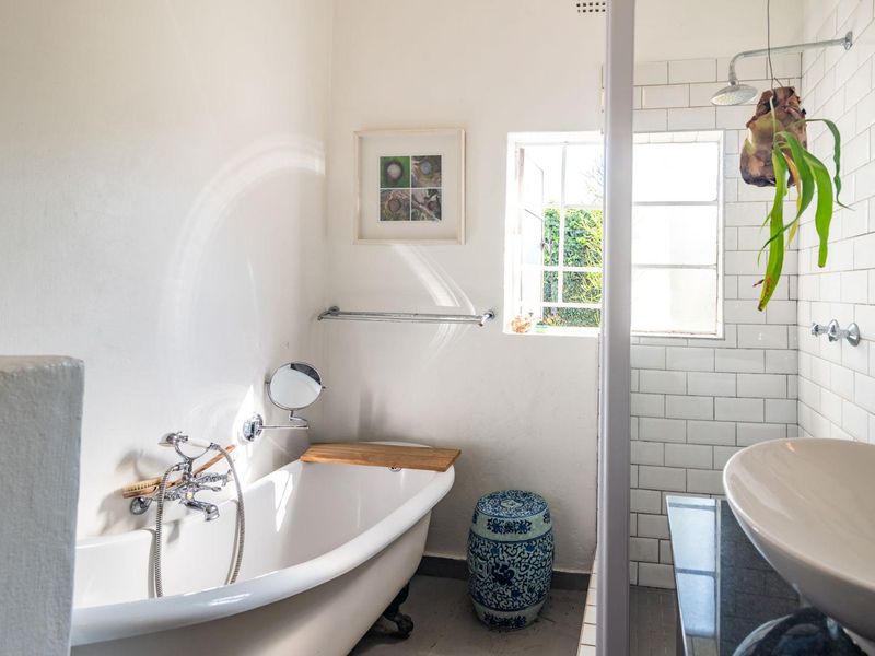 Bright bathroom featuring a classic freestanding bathtub, a separate shower with subway tiling, and a modern vessel sink vanity.