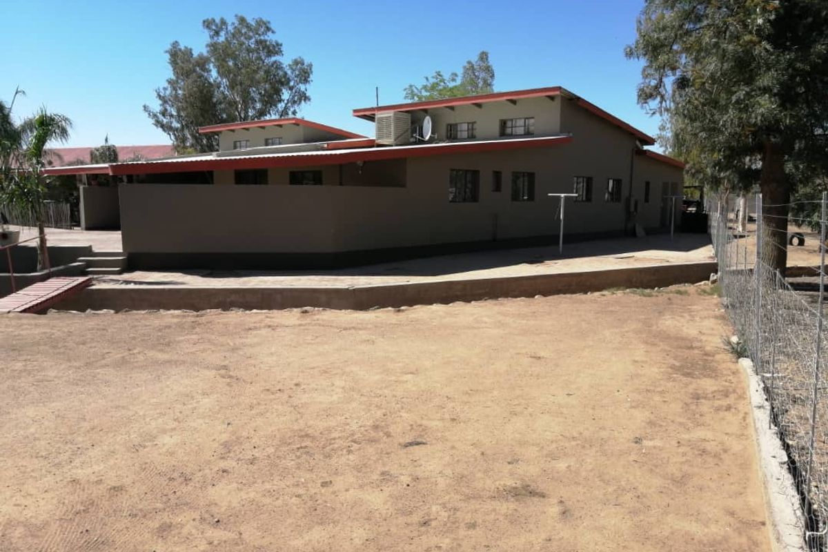A view of the rear exterior of the house, featuring a concrete patio area and a large, undeveloped yard space.