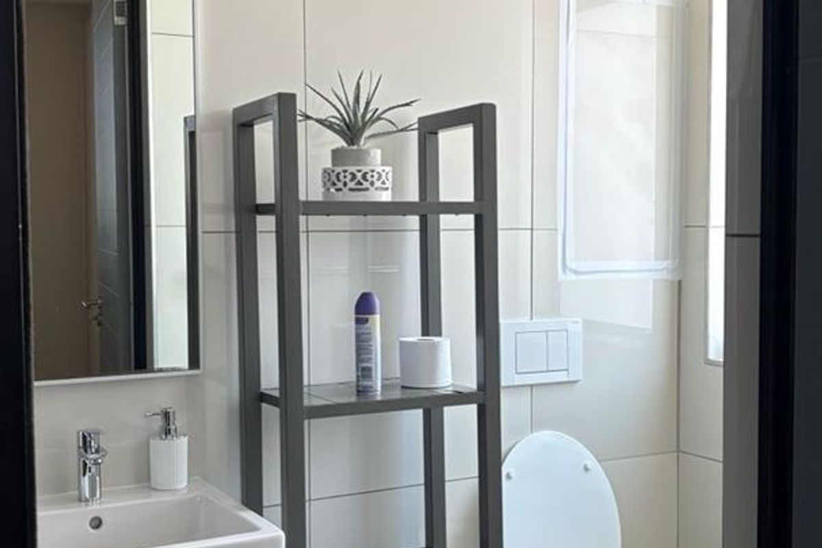 Modern bathroom featuring a wall-mounted basin, wall-hung toilet with concealed cistern, and neutral ceramic tiling throughout.