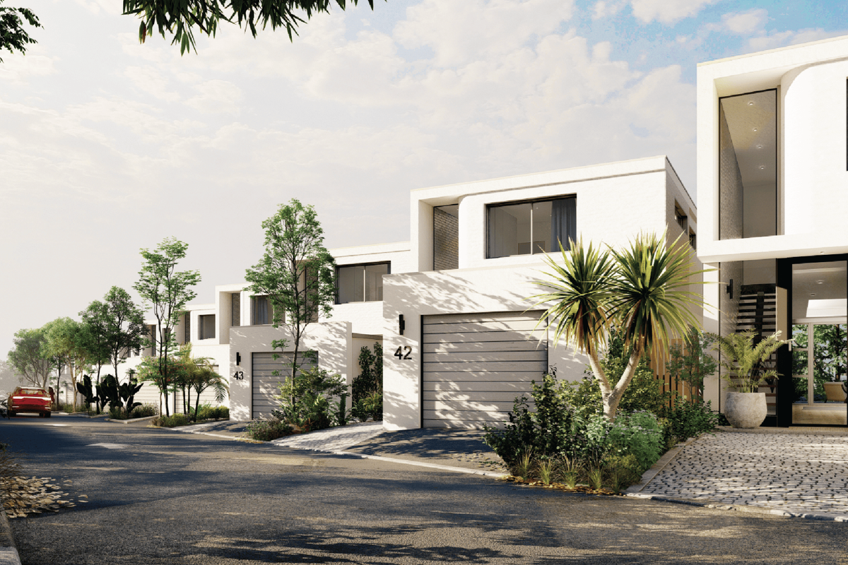 A street-level view of a modern townhouse complex featuring contemporary architectural design, paved driveways, and integrated garage access.