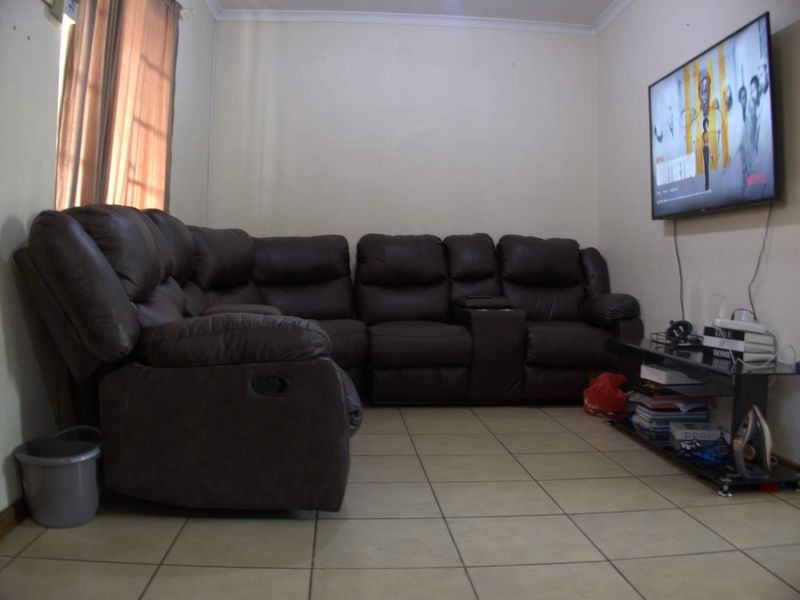 A living room featuring tiled flooring and standard wall finishes, providing a functional space for relaxation.